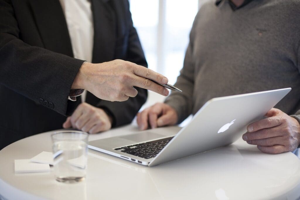 Two men consulting over a computer