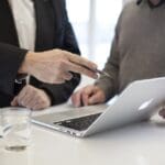 Two men consulting over a computer