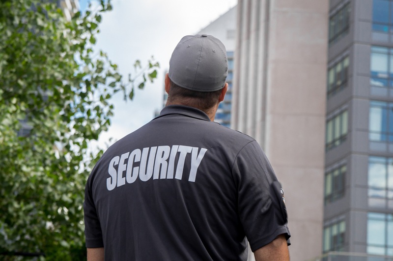 A security guard in front of a tall building.