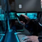 A security guard looking at a computer monitor.